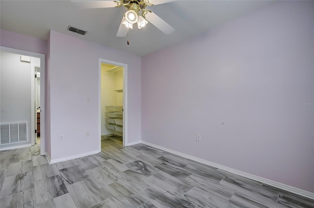 unfurnished bedroom with ceiling fan, a closet, and a walk in closet