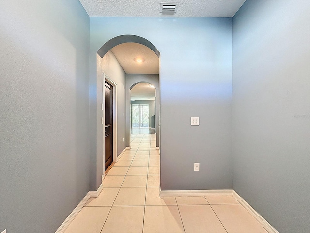 corridor with light tile patterned floors