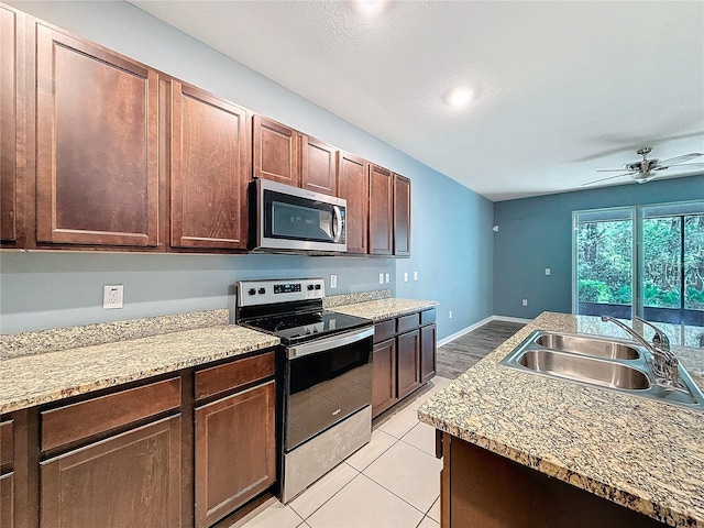 kitchen featuring dark brown cabinetry, ceiling fan, sink, stainless steel appliances, and light tile patterned floors