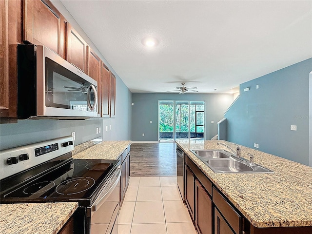 kitchen featuring ceiling fan, sink, a kitchen island with sink, light tile patterned floors, and appliances with stainless steel finishes