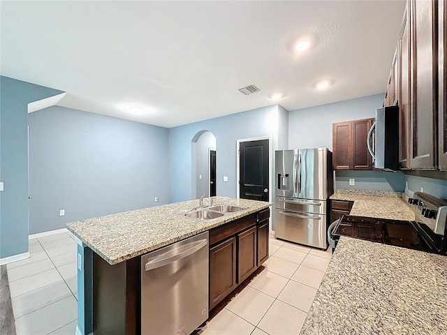 kitchen featuring sink, a center island with sink, light tile patterned floors, and appliances with stainless steel finishes