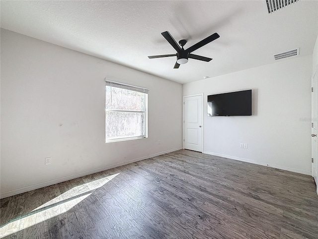 spare room featuring a textured ceiling, dark hardwood / wood-style flooring, and ceiling fan