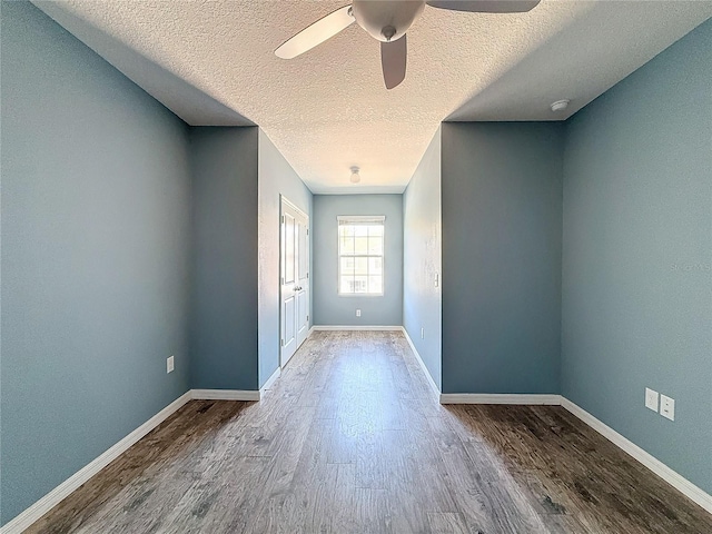 doorway with hardwood / wood-style flooring, ceiling fan, and a textured ceiling