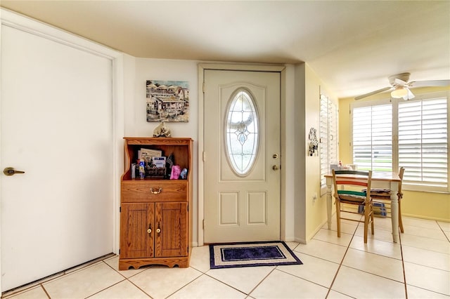 foyer featuring lofted ceiling, light tile patterned floors, and ceiling fan