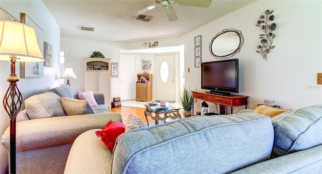 living room with ceiling fan, a textured ceiling, and light tile patterned floors