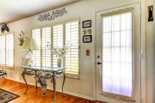 doorway with hardwood / wood-style floors and a textured ceiling