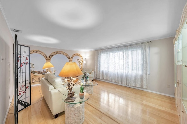 living room featuring light hardwood / wood-style floors and crown molding