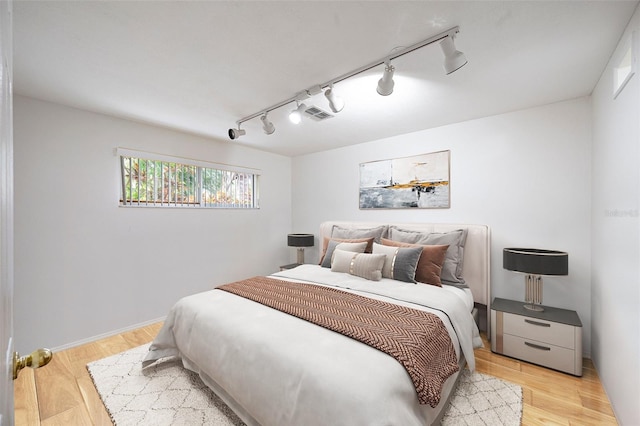 bedroom with light wood-type flooring and rail lighting