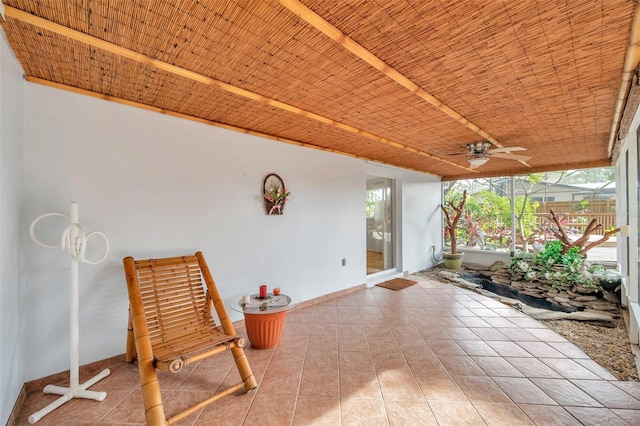 unfurnished sunroom featuring ceiling fan