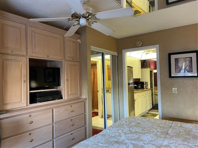 20857 Haulover Cv Unit B-13, Lutz, FL 33558 - bedroom featuring freestanding refrigerator, connected bathroom, ceiling fan, and a textured ceiling