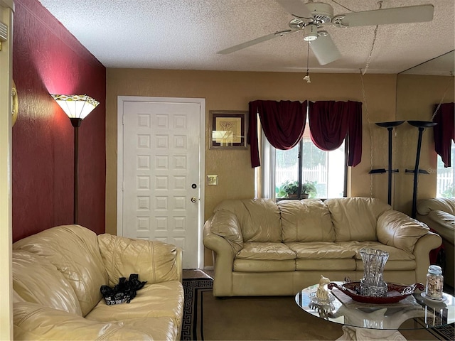 living room featuring a textured ceiling and ceiling fan