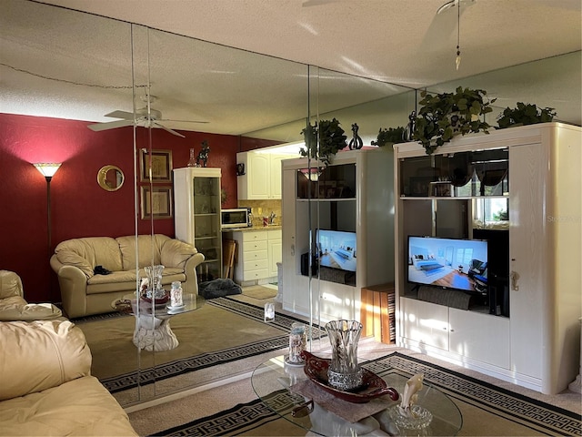 living room with a textured ceiling and ceiling fan