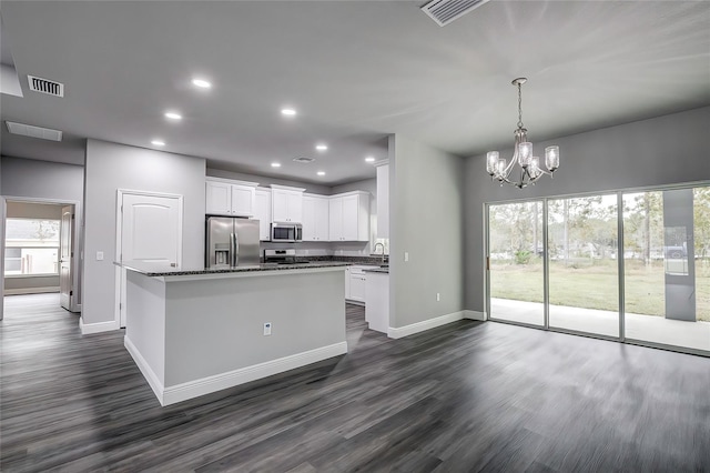 kitchen with white cabinets, stainless steel appliances, a kitchen island, and a wealth of natural light