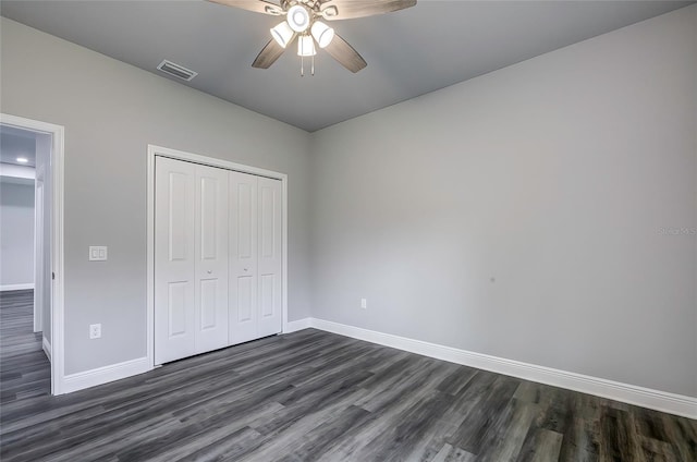 unfurnished bedroom with ceiling fan, dark hardwood / wood-style floors, and a closet