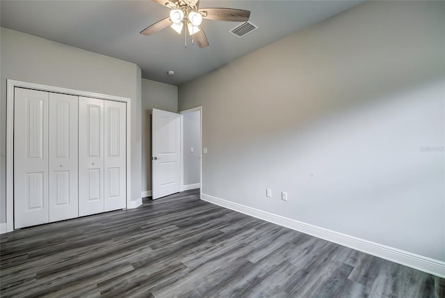 unfurnished bedroom featuring dark hardwood / wood-style flooring, a closet, and ceiling fan