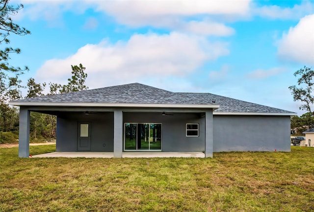 back of property with a lawn, a patio area, and ceiling fan