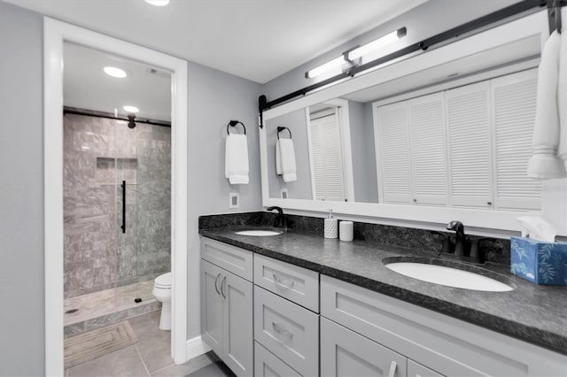 bathroom featuring tile patterned flooring, vanity, toilet, and walk in shower