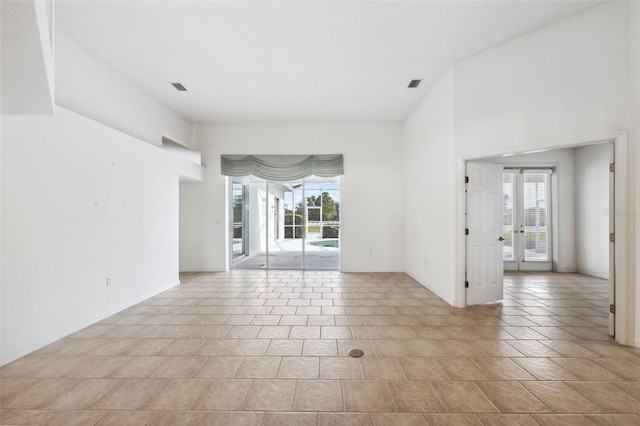 spare room featuring a wealth of natural light and light tile patterned floors