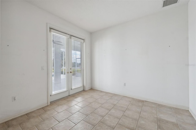 empty room with french doors and light tile patterned floors