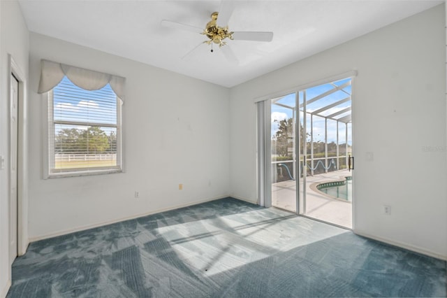 carpeted spare room with ceiling fan