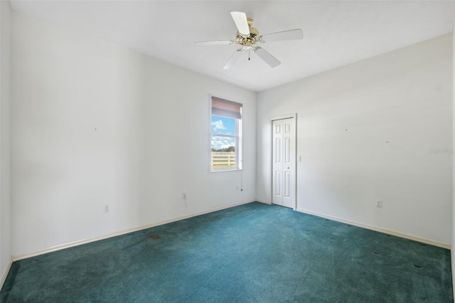 unfurnished room with ceiling fan and dark carpet