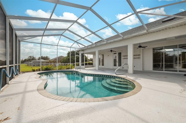 view of swimming pool featuring a patio, ceiling fan, and glass enclosure