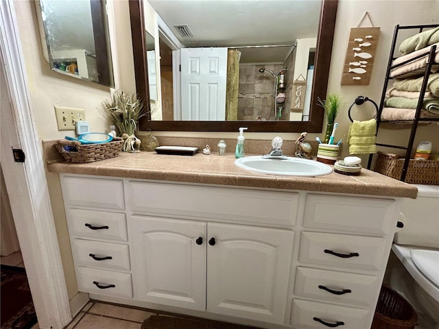 bathroom with walk in shower, vanity, toilet, and tile patterned flooring