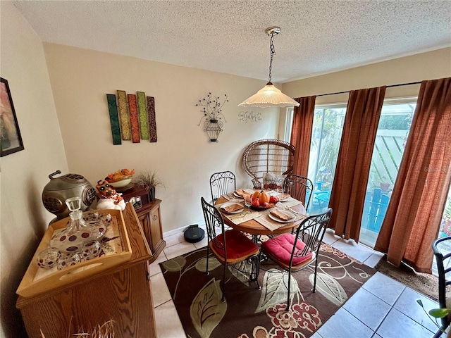 dining space featuring a textured ceiling and light tile patterned flooring