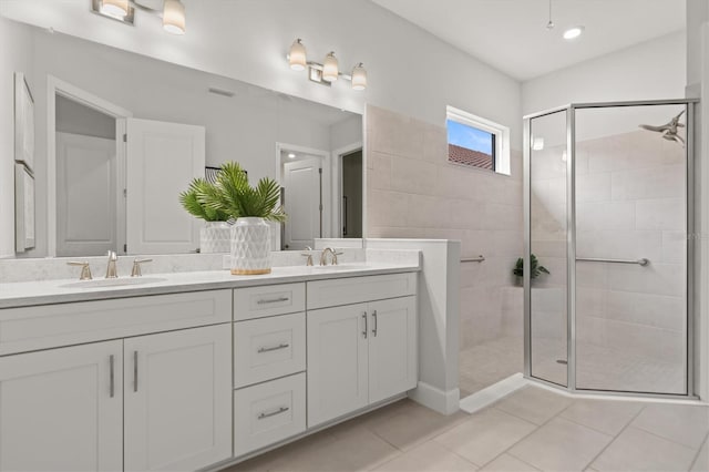 bathroom featuring vanity, tile patterned flooring, and tiled shower