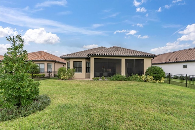 back of property with a sunroom and a yard