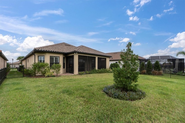 rear view of property with a sunroom and a yard