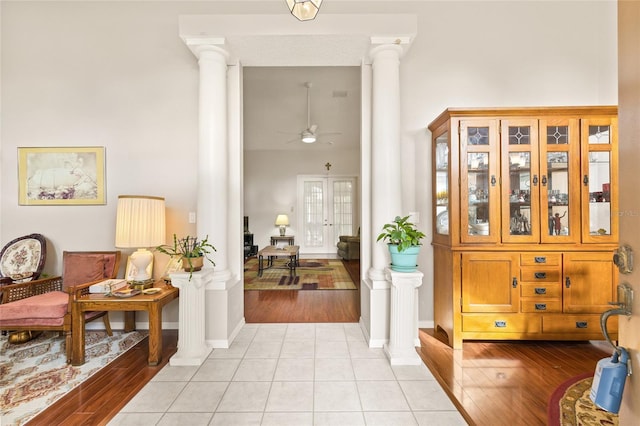 entrance foyer with light hardwood / wood-style flooring, ceiling fan, and ornate columns