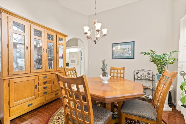 dining area with dark hardwood / wood-style flooring and an inviting chandelier