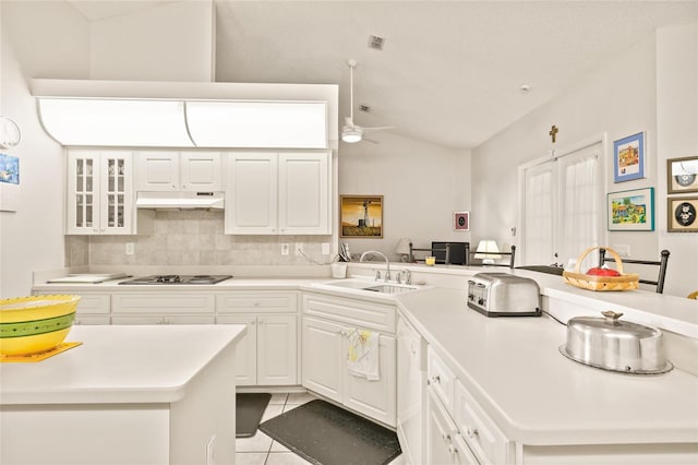 kitchen featuring gas cooktop, backsplash, vaulted ceiling, sink, and light tile patterned flooring