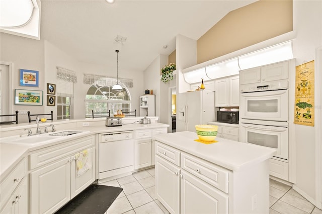 kitchen featuring light tile patterned flooring, white appliances, sink, and vaulted ceiling