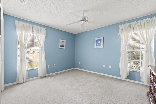 unfurnished room with ceiling fan, carpet floors, and a textured ceiling