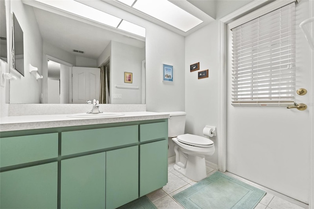 bathroom with tile patterned flooring, vanity, and toilet