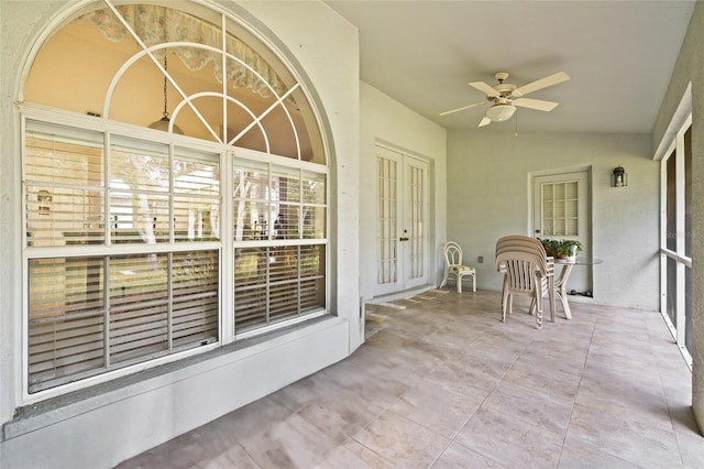 unfurnished sunroom with ceiling fan, lofted ceiling, and french doors