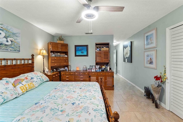 bedroom with light tile patterned flooring, ceiling fan, and a textured ceiling