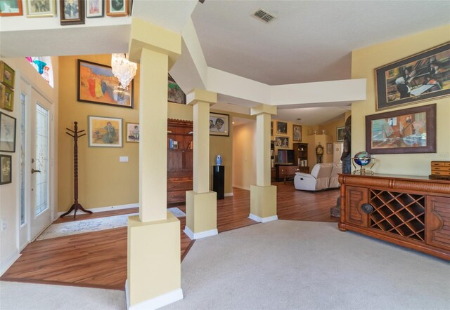 foyer entrance featuring ornate columns and light hardwood / wood-style flooring