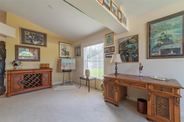 carpeted office with lofted ceiling