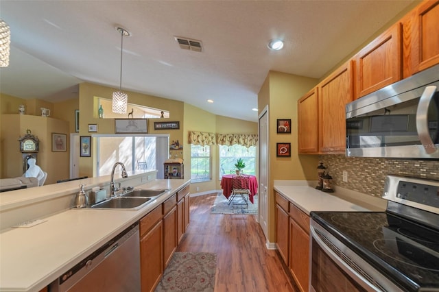 kitchen featuring stainless steel appliances, sink, dark hardwood / wood-style floors, lofted ceiling, and pendant lighting