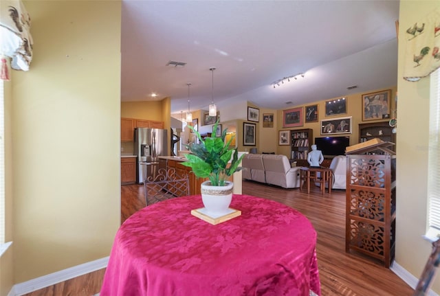 dining space featuring dark hardwood / wood-style floors and vaulted ceiling