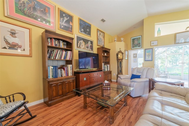 living room featuring wood-type flooring, built in features, and vaulted ceiling