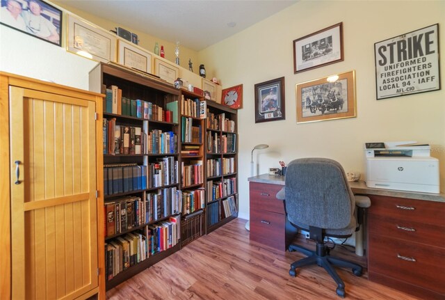 home office with light hardwood / wood-style floors