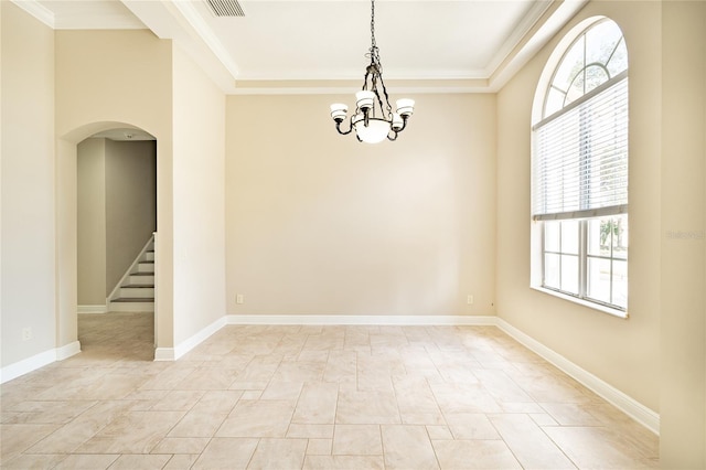 empty room with crown molding, a wealth of natural light, and a chandelier