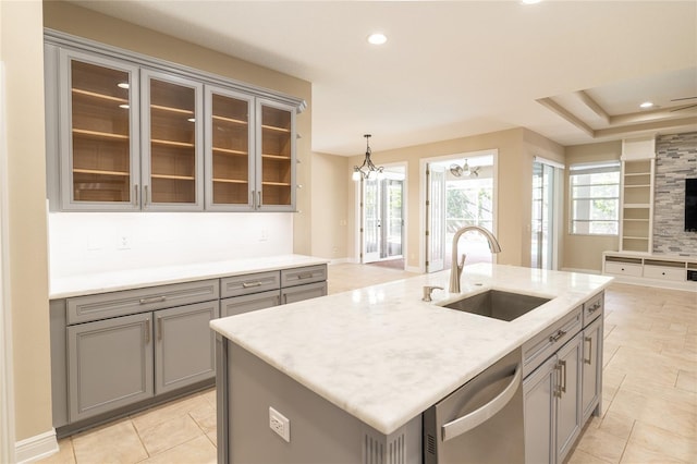 kitchen featuring gray cabinetry, sink, dishwasher, and a center island with sink