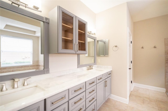 bathroom with tile patterned flooring, vanity, and decorative backsplash