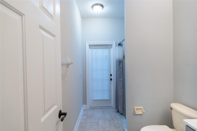 bathroom with vanity, toilet, and a textured ceiling