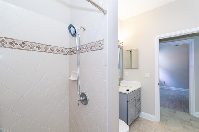 bathroom with vanity, tile patterned flooring, and a tile shower